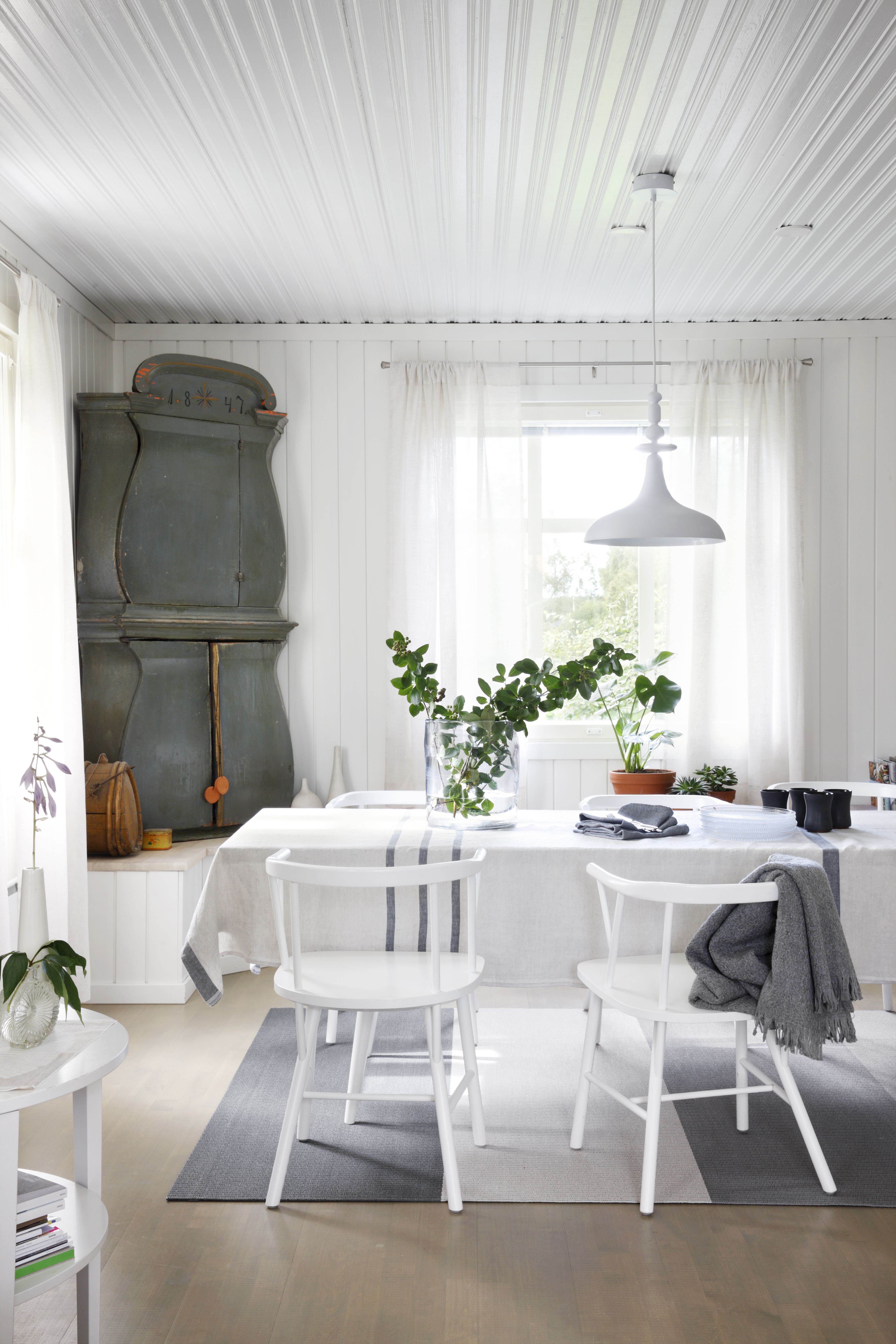 Vanhan perintökaapin väritys toi saven sävyt alakertaan. Artekin ruokapöytä on palvellut pitkään. Sen ilme uudistuu moderneilla pellavaliinoilla. Woodnotesin matto on valmistettu Lapualla, ja oli siksi itsestäänselvä hankinta. Sirot ja mukavat NC Möblerin pinnatuolit on suunnitellut Björn Dahlström. Kattovalaisin on Henrik Pedersenin Bolialle suunnittelema Bazar. Kaikki tekstiilit ovat Lapuan Kankureiden.