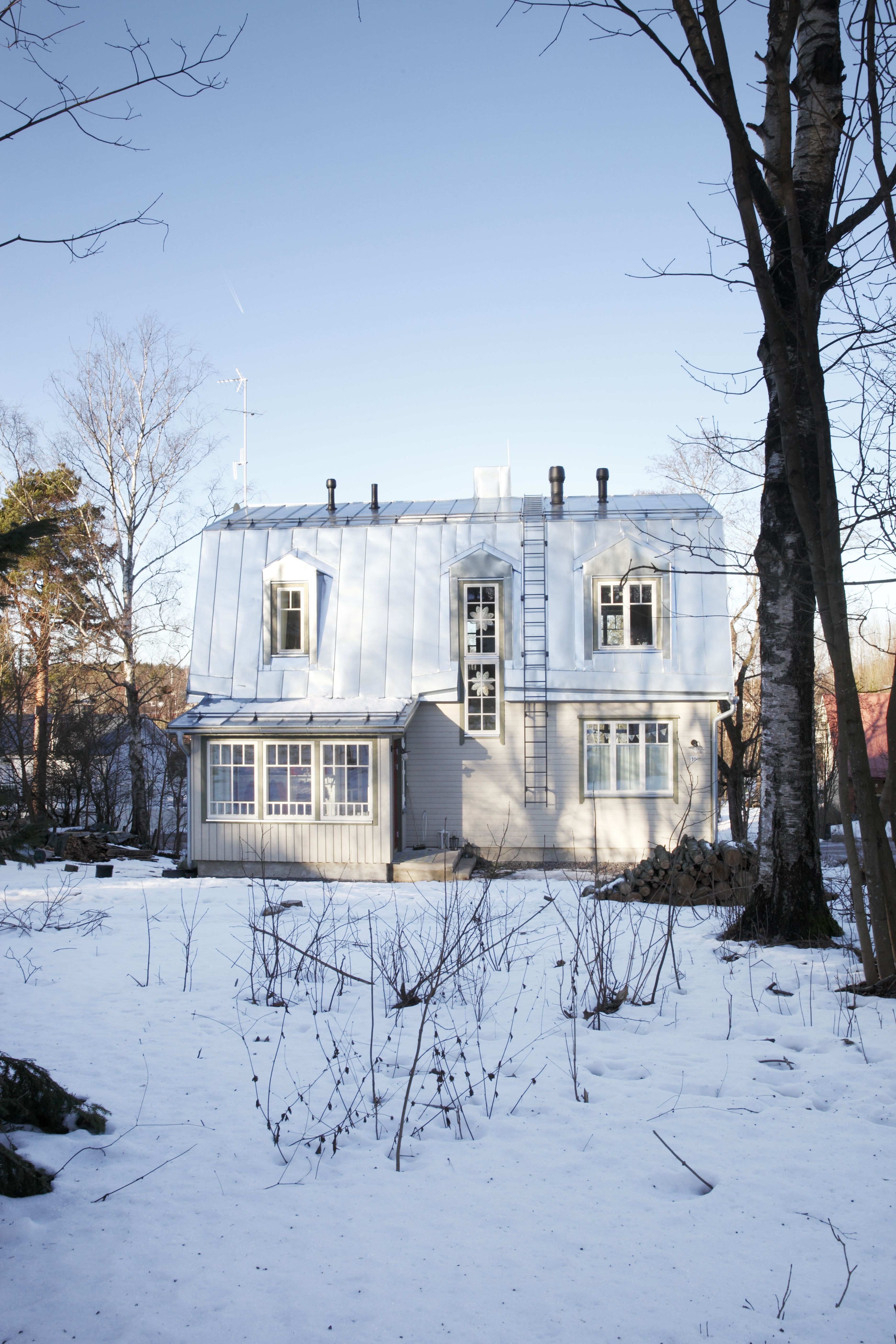 Uusi talo sopii ympäröivään puutalomiljööseen.