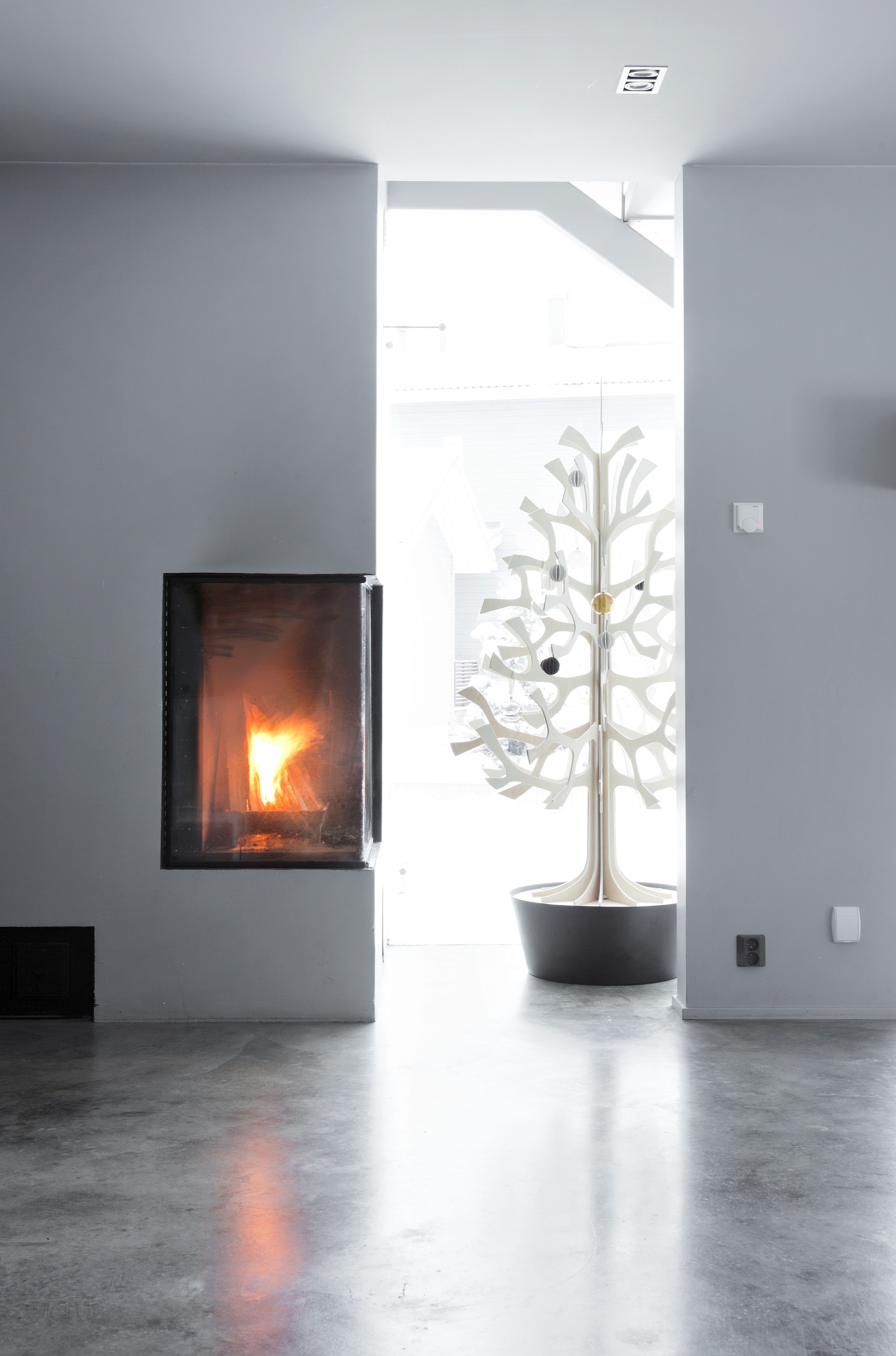 Arkkitehdin suunnittelema takka-leivinuuniyhdistelmä on sijoitettu keittiön lähelle niin ovelasti, ettei sitä huomaa muusta kuin lämmöstä, jota se hohkaa ympärilleen kylminä talvipäivinä. Portaiden alta Lovin vanerikuusi näkyy keittiöön, olohuoneeseen ja ulos.