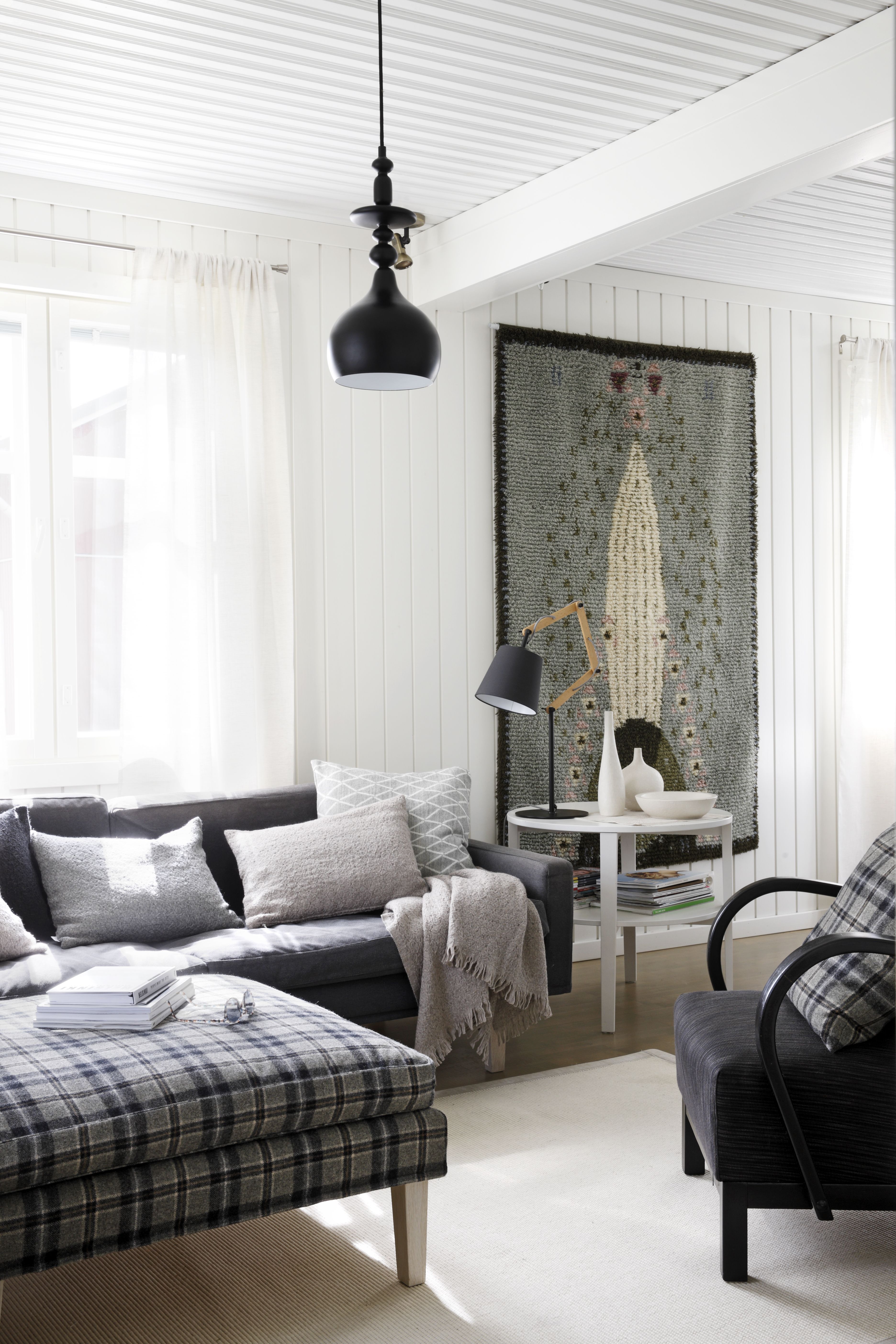 Olohuonenurkkaukseen hankittiin Valannin sohvat. Seinällä on Eliel Saarisen Ruusu-ryijy, jonka Jaana hankki muistoksi Suomen Käsityön Ystävien kanssa tekemästään yhteistyöstä. Musta pöytävalaisin ostettiin espanjalaiselta messunaapurilta. Pullean maljakon Jaana sai Anu Pentikiltä odottaessaan kaksosiaan.