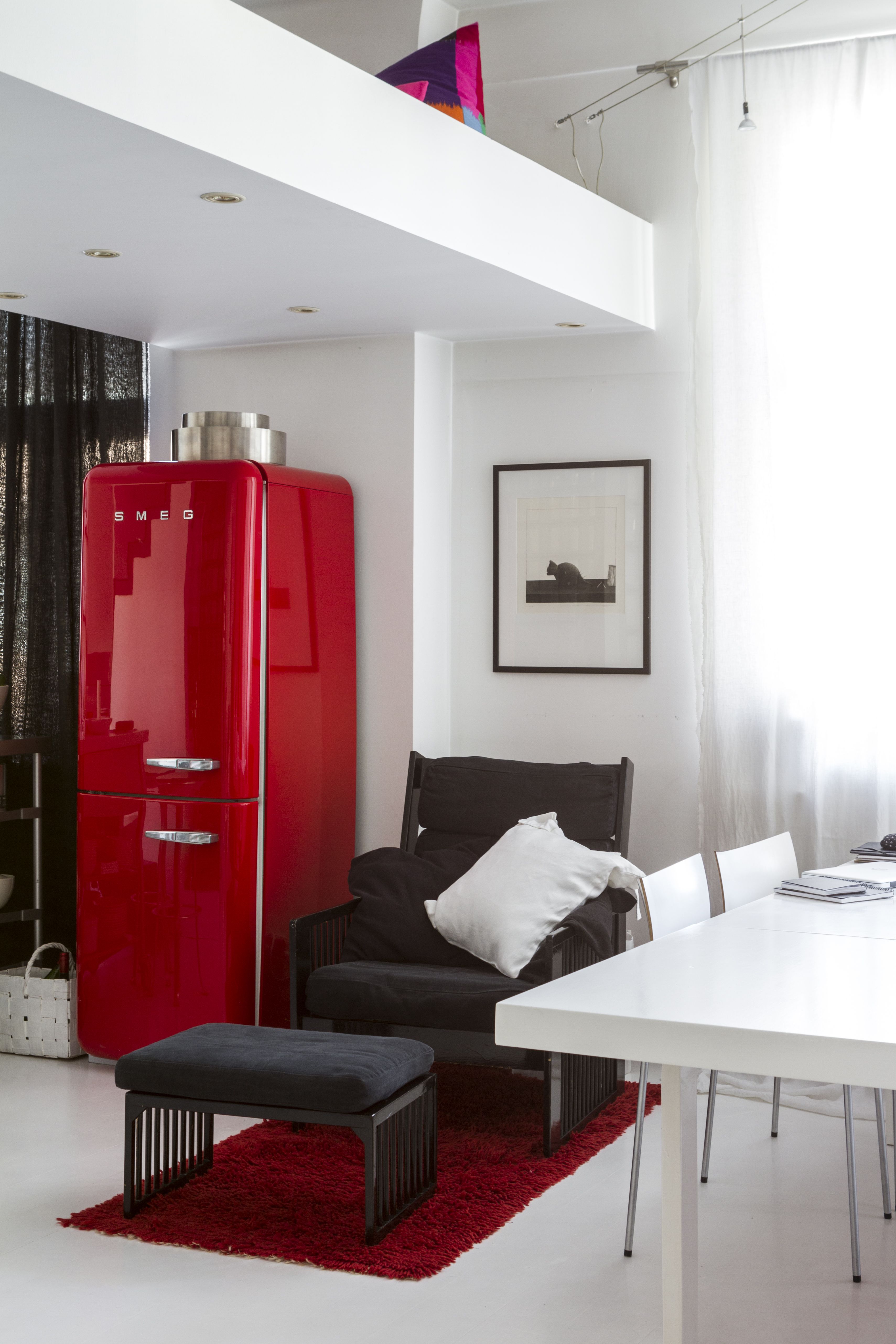 Valaistus on upotettu parven alapuolelle. Punainen jääkaappi on Smegin. Musta nojatuoli ja rahi ovat Ben af Schultenin. Seinällä on Pentti Kaskipuron grafiikkatyö. Valkoiseksi maalattu, pitkä pöytä oli 1950-luvulla Artekin neuvottelutiloissa, ja sen on suunnitellut Alvar Aalto. Tuolit ovat Antti Kotilaisen Piiroiselle suunnittelemat.