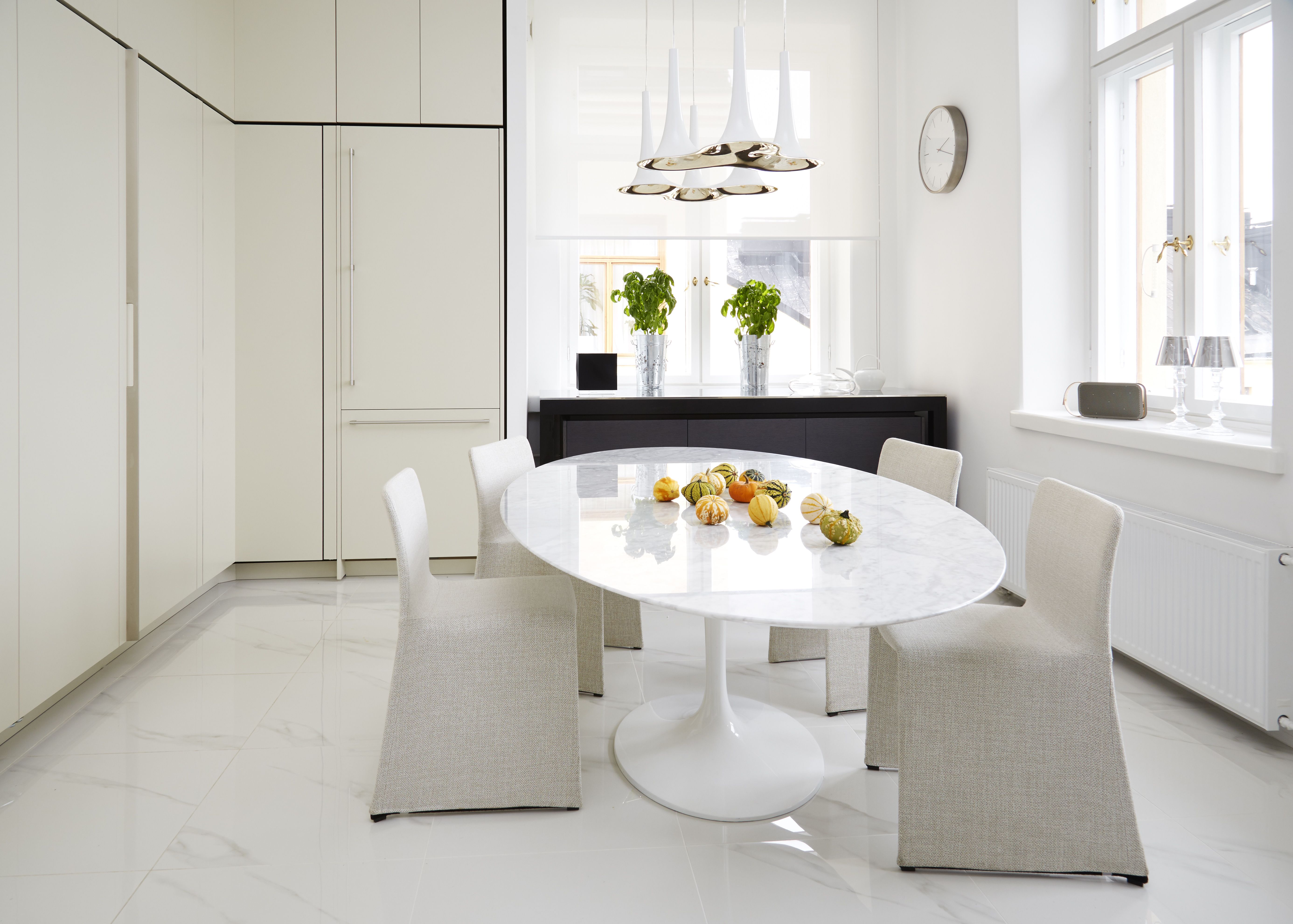 Eero Saarisen marmorista Tulppaani-pöytää pehmentävät Patricia Urquiolan suunnittelemat Glove-tuolit. Axolightin Nafir-valaisin on kaunis ilman valaistustakin.