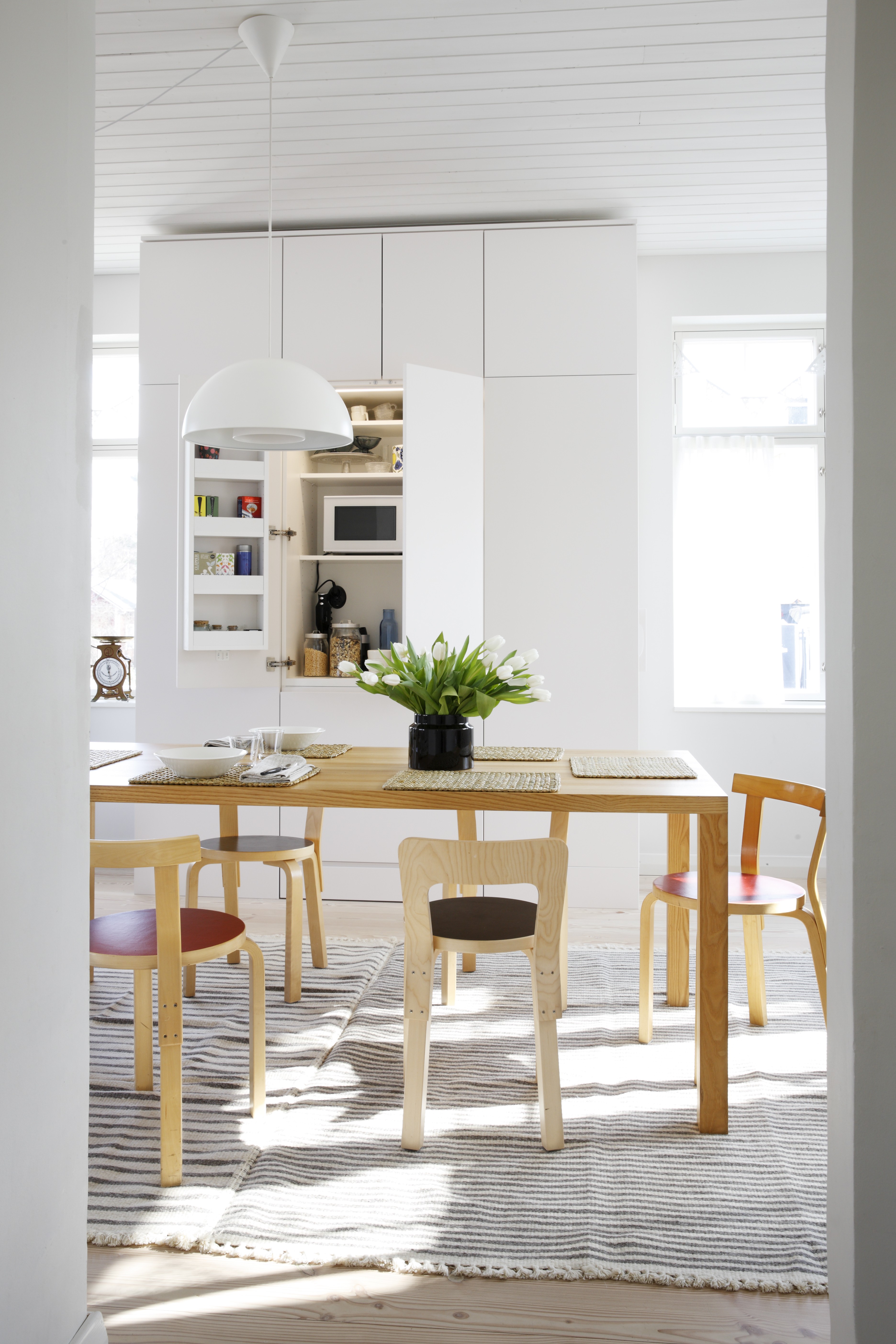 Avaran ja valoisan keittiön kaapit ovat Hanni Koroman piirtämiä ja puusepän toteuttamia. Kaikki aamiaistarvikkeet ja välineet löytyvät keskiosasta. Kaapin päädyissä ovat kylmälaitteet. Ruokapöytä on teetetty täyspuusta, tuolit ovat Artekin ja lampaanvillamatot ovat Tikaun.