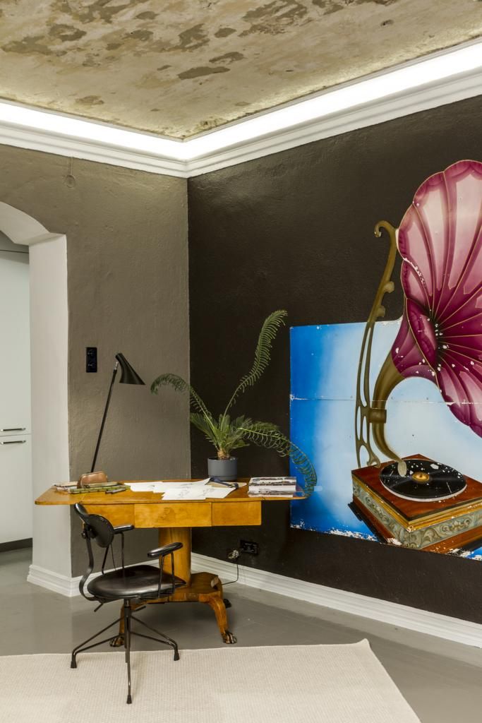 Teemu työskentelee myös kotona. Vanha tassujalkainen kirjoituspöytä toimii tarvittaessa ruokapöytänä. Katon rajaan on upotettu pehmeä koristevalo.