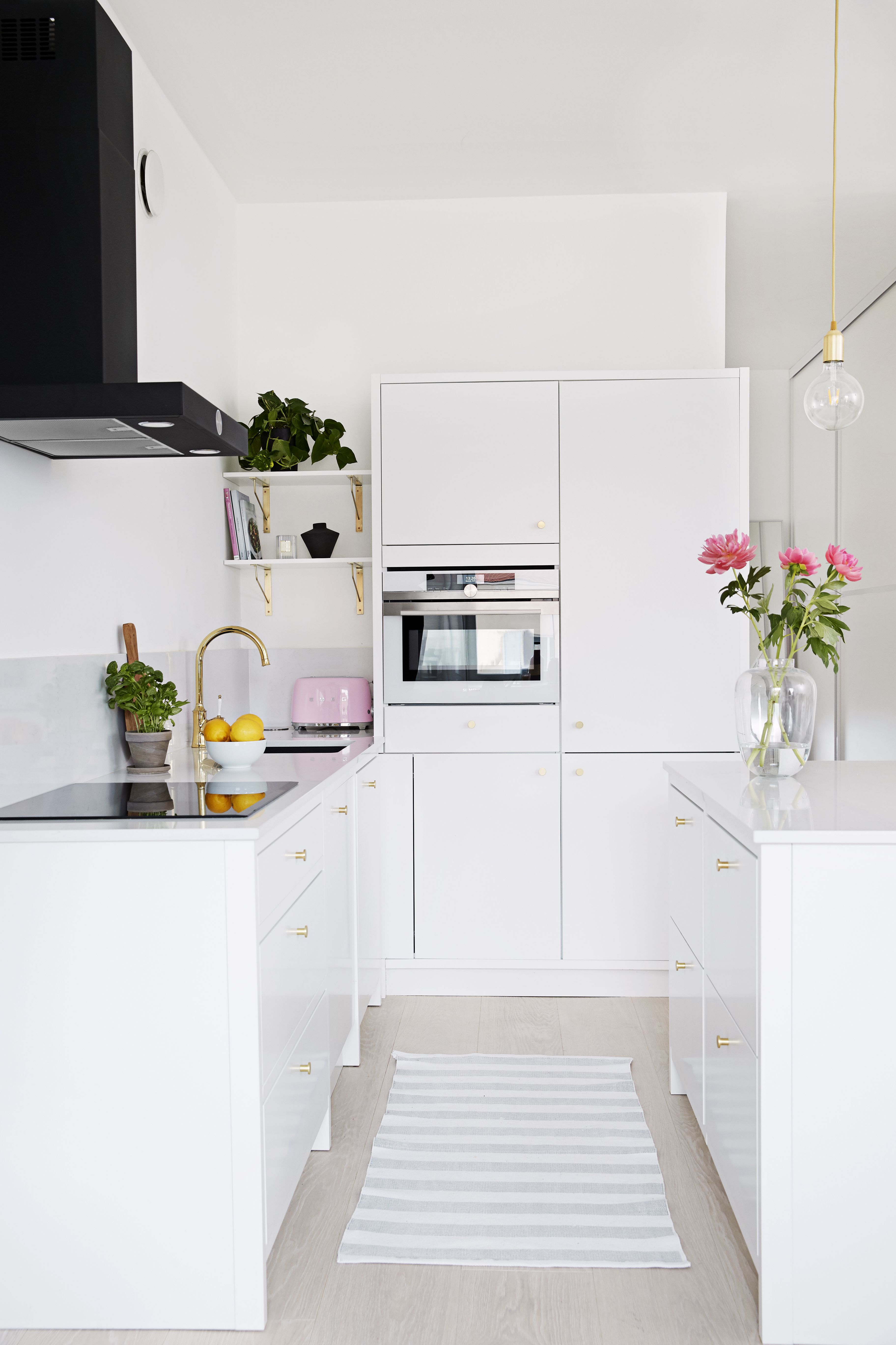 Janna valitsi keittiöönsä runsaasti messinkisiä yksityiskohtia sekä mustan liesituulettimen tuomaan ryhtiä muuten vaaleaan kokonaisuuteen.